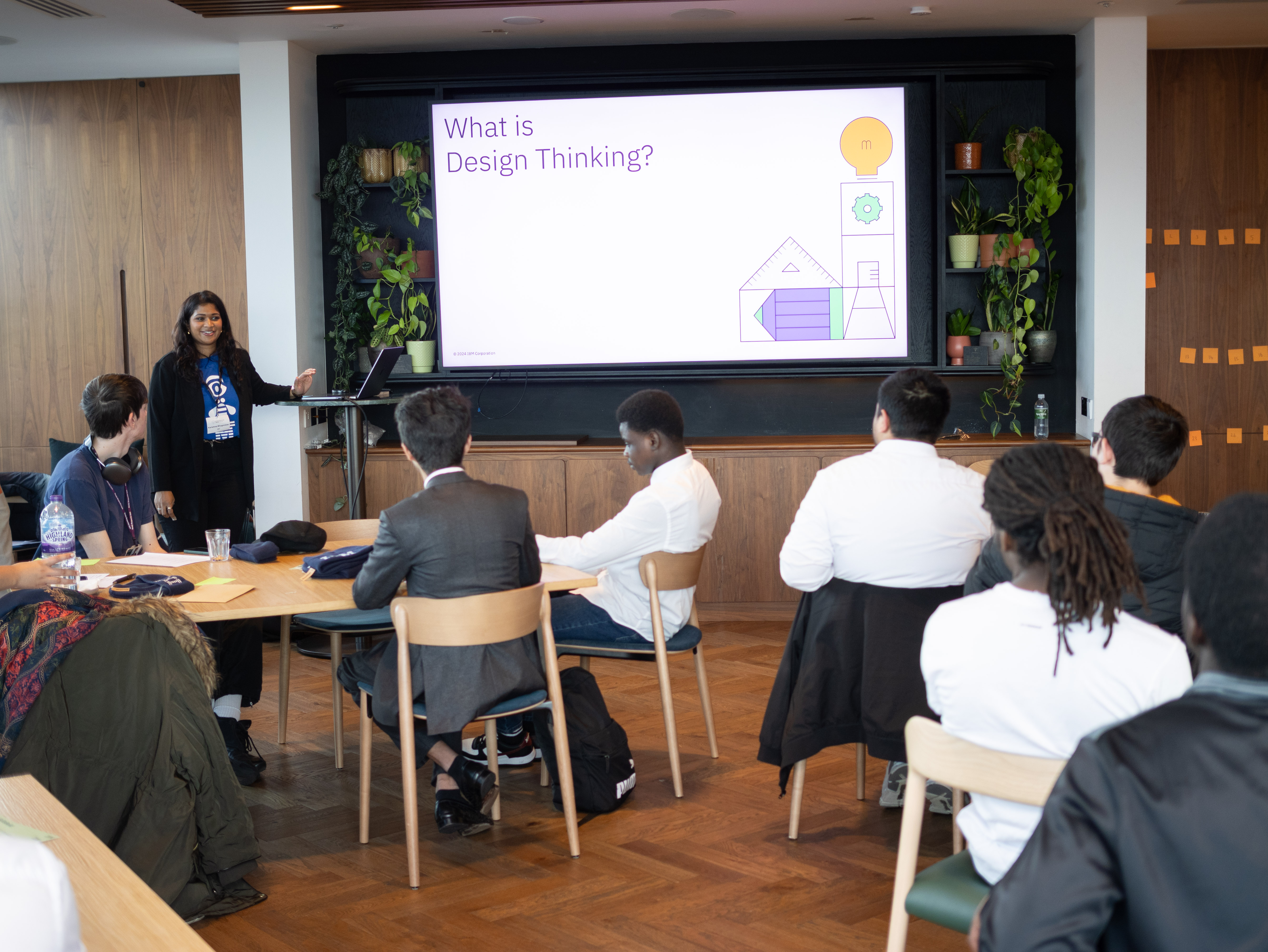 Karishma presenting a 'What is Design Thinking?' slide to a room of workshop participants